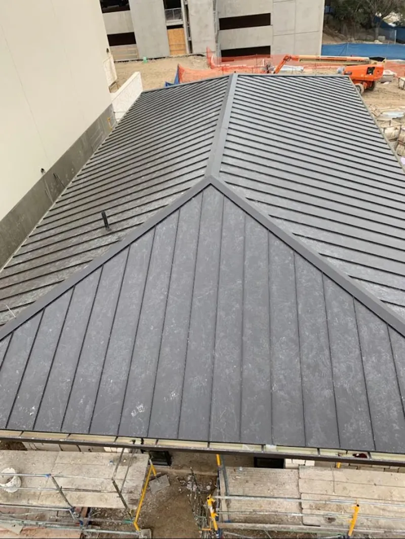 Commercial metal roof construction with crane equipment in Salina